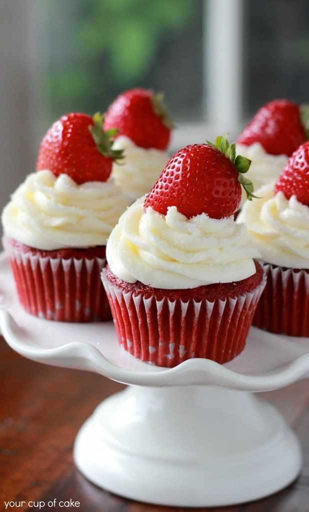 strawberry cupcakes with white frosting and fresh strawberries on top