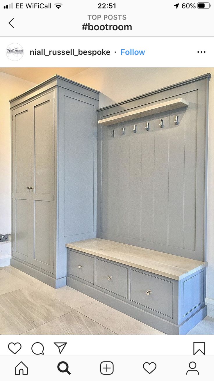 an image of a room with grey cabinets and drawers on the bottom shelf, in front of a white wall