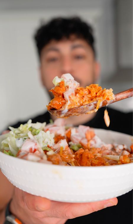 a man holding a spoon full of food