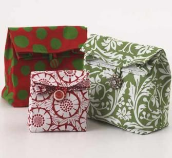 three different colored bags sitting next to each other on a white surface with green and red designs