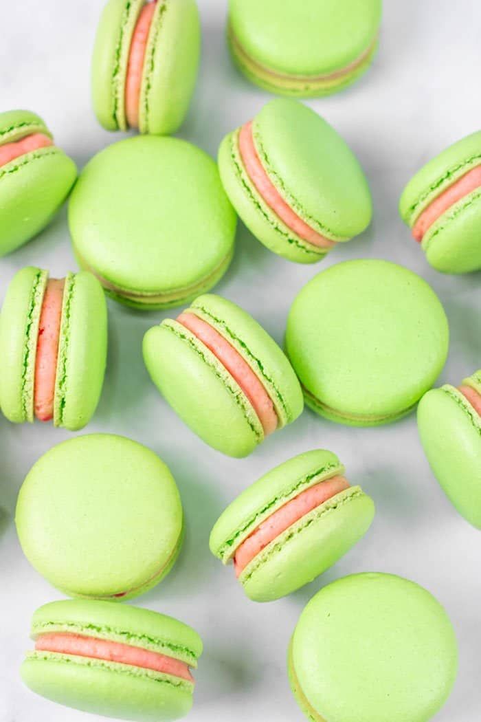 green macarons with pink and white stripes on them, surrounded by the words guava macarons