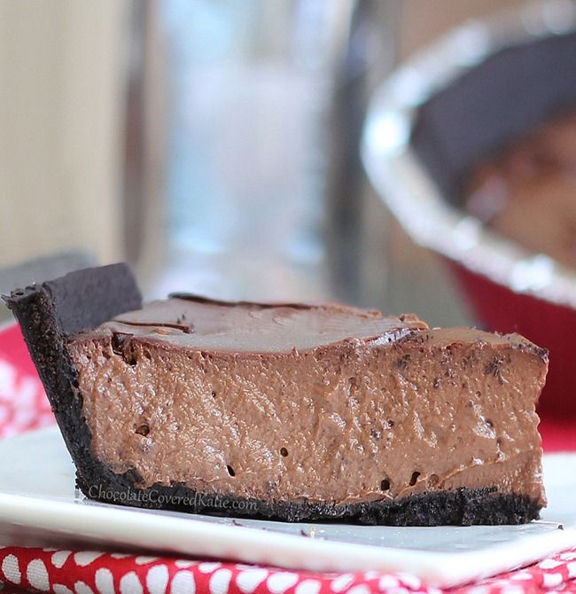 a piece of chocolate cheesecake on a plate with a pie pan in the background