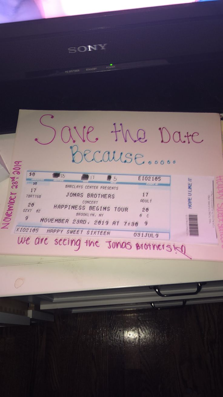 a pink and white ticket sitting on top of a table next to a tv screen