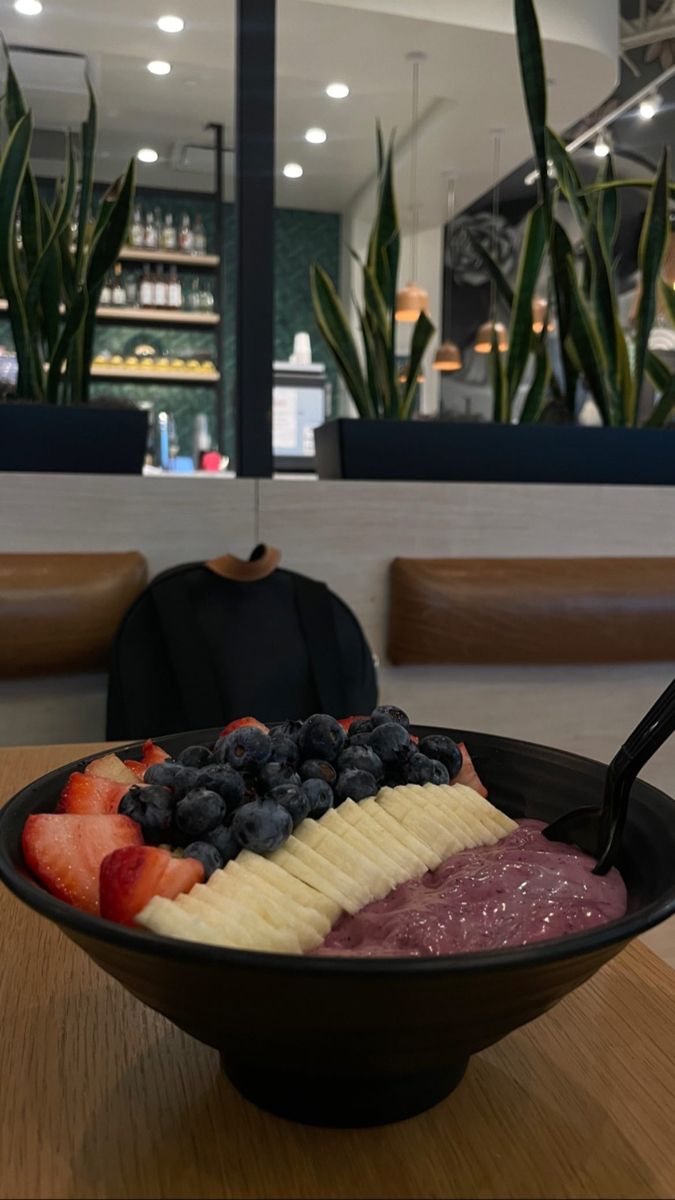 a bowl filled with fruit on top of a wooden table