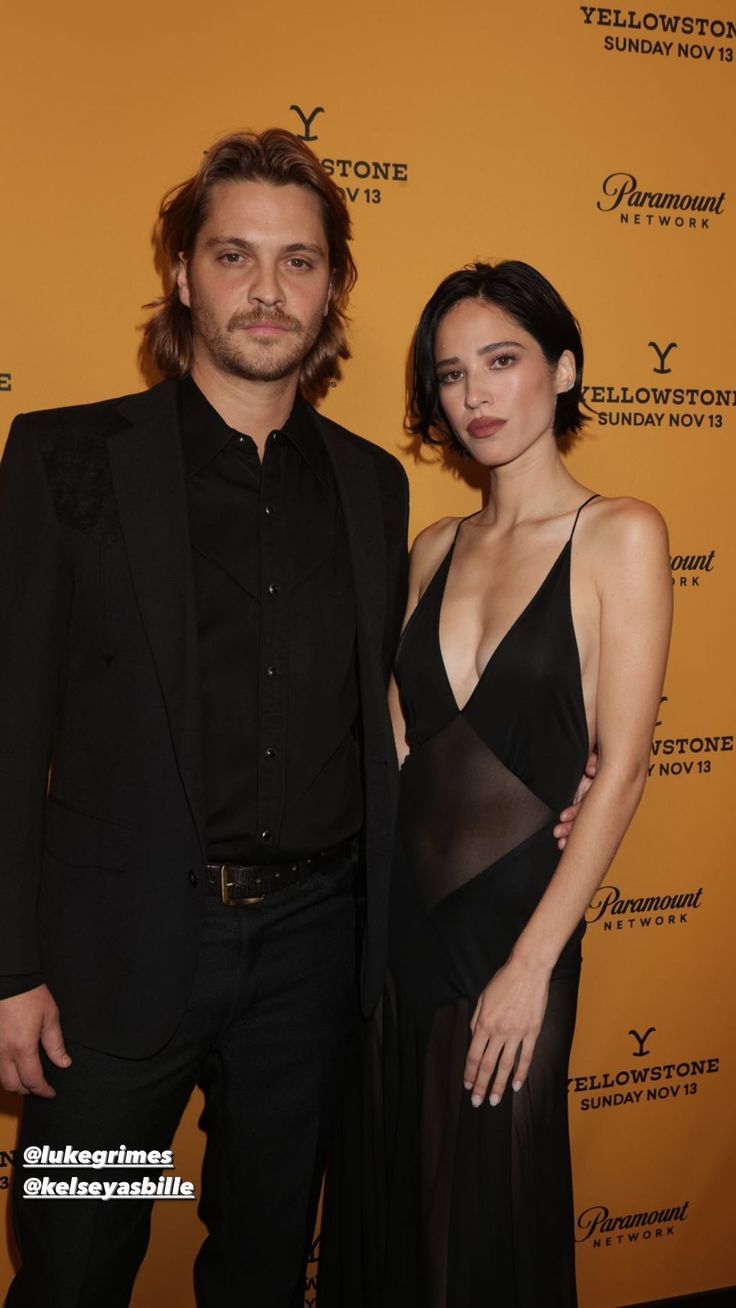 a man and woman standing next to each other on a red carpet at an event