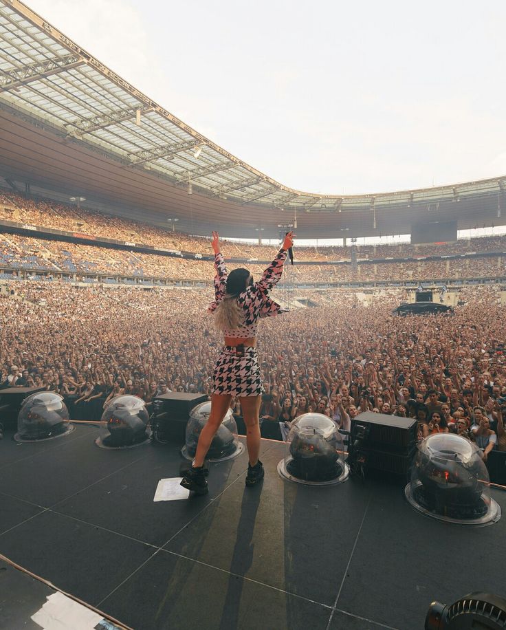 a man standing on top of a stage in front of an audience at a concert