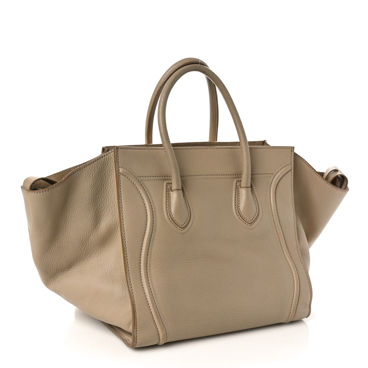 This is an authentic CELINE Smooth Calfskin Medium Phantom Luggage in Taupe. This is a stylish bag that is a large tote or a small piece of luggage crafted of luxurious leather. The top handles are smooth and easy to use and the frontal scroll details make it easy to look at. The top is open to a suede interior with zipper and patch pockets. It is a wonderful size for a day tote or an ideal over-night bag and the expandable sides will adjust accordingly. This is an excellent travel tote from Celine! Travel Tote, Stylish Bag, Large Tote, Easy To Use, Patch Pocket, Calf Skin, To Look, Handles, Zipper