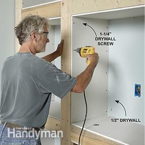 a man using a drill to attach screws on the wall in front of him