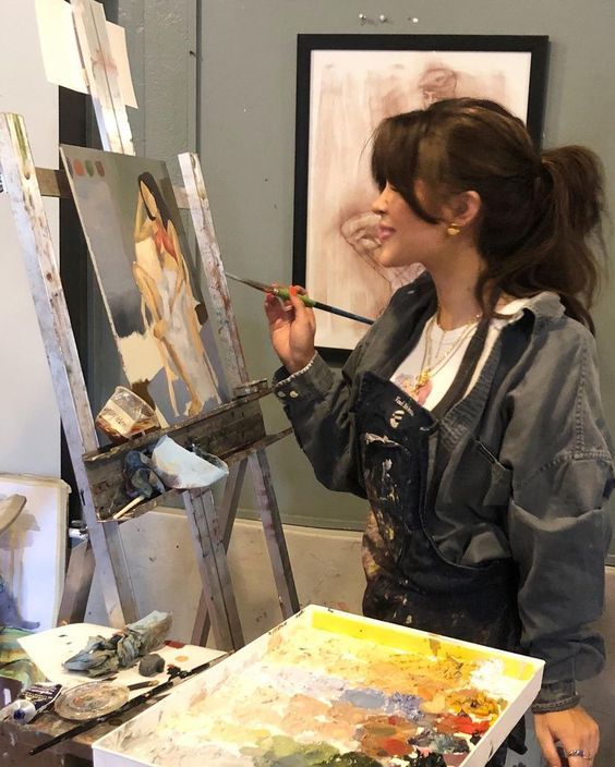 a woman is painting in an art studio