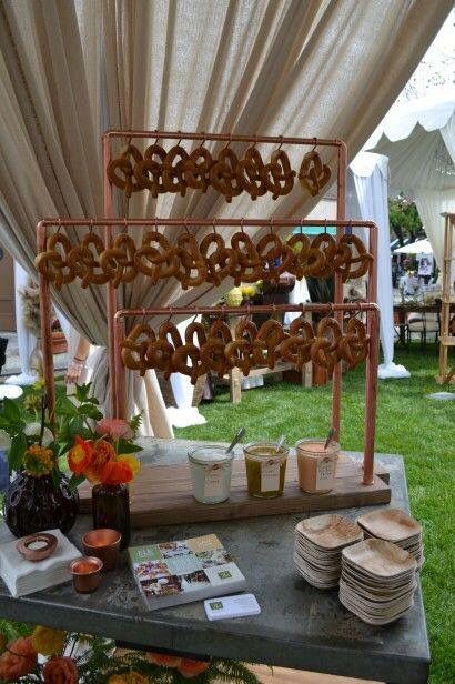 a table topped with lots of donuts on top of a green field next to a white tent