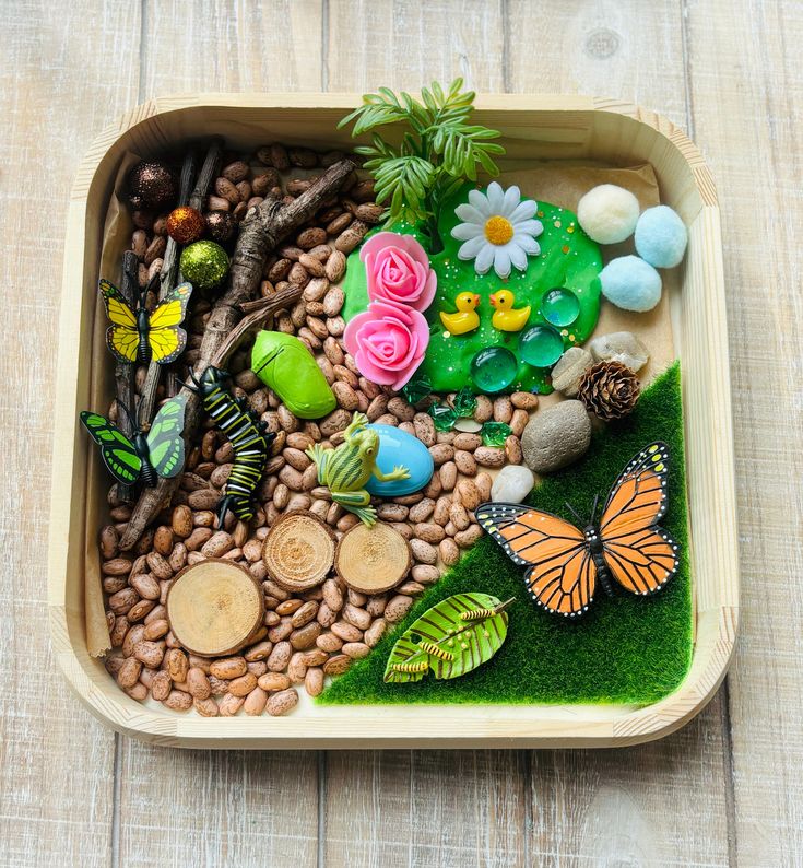 a wooden tray filled with rocks and plants