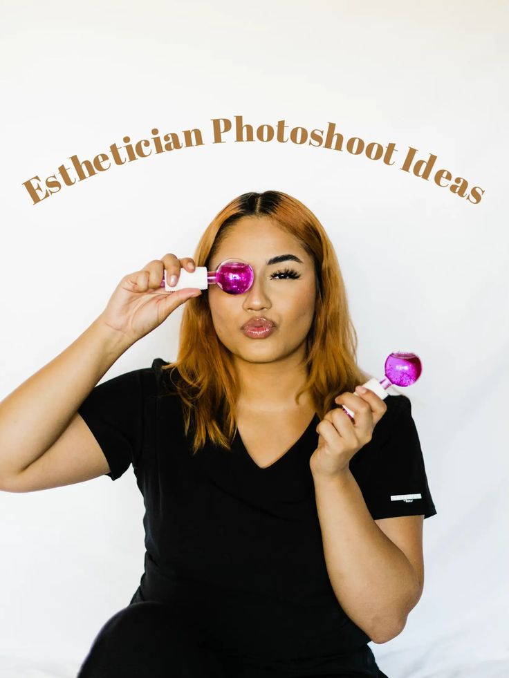 a woman is holding up two pink lollipops in front of her eyes