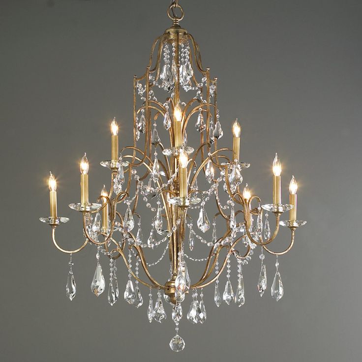 a gold chandelier with crystal drops hanging from it's center and four lights on each side