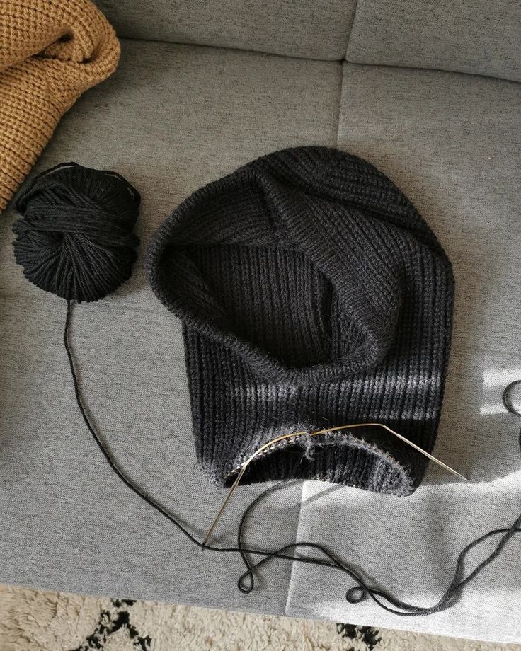 a hat, yarn and scissors on a couch