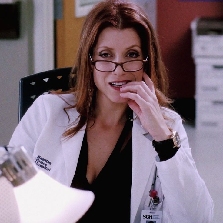 a woman wearing glasses sitting at a desk