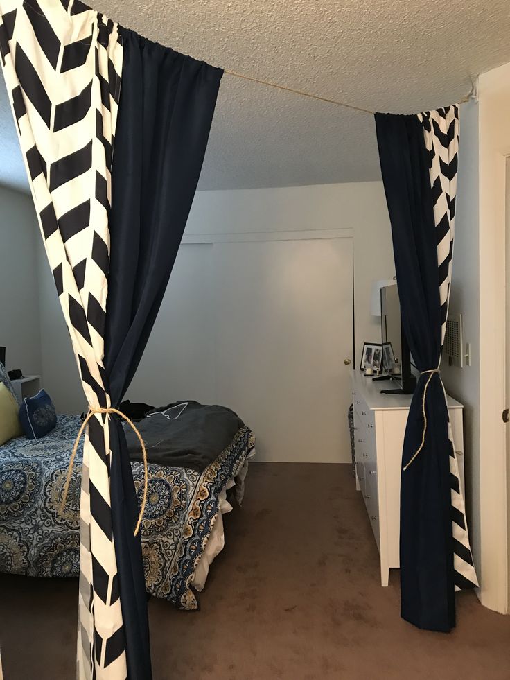 a bedroom with black and white drapes on the ceiling