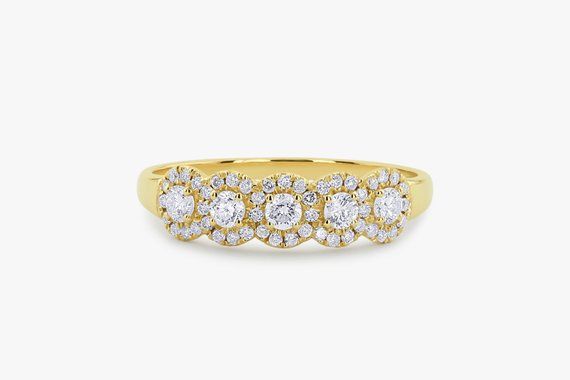 a yellow gold ring with three rows of round diamonds on the top, and one row of smaller white stones in the middle