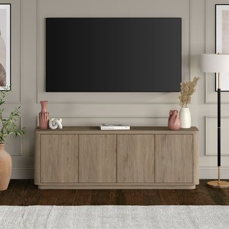 On-trend shape and design combine in this 68" TV stand. With a wood grain finish and sleek flush doors, this piece is sure to be a statement in your living room, den, or game room. The plinth base gives an illusion of a seamless transition from your floor, while the rounded front corners create a softer modern shape. The console features 4 inner shelves with cable management cutouts, allowing for ample storage and organization of your devices, games, books, and more. Size: 68" W x 15.5" D x 24" Transitional Tv Stand, Tv Stand Decor Living Room, Oak Tv Stand, Tv Stand Decor, Colour Gray, Flush Doors, Tv Stand Wood, Living Room Tv Stand, Tv Stands And Entertainment Centers