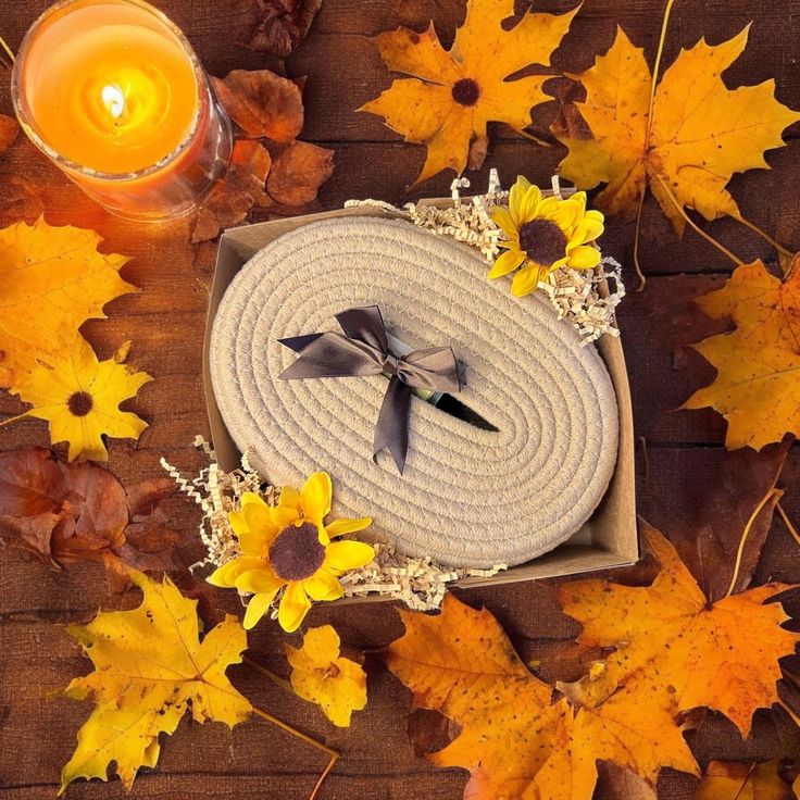 an arrangement of autumn leaves and candles on a wooden table