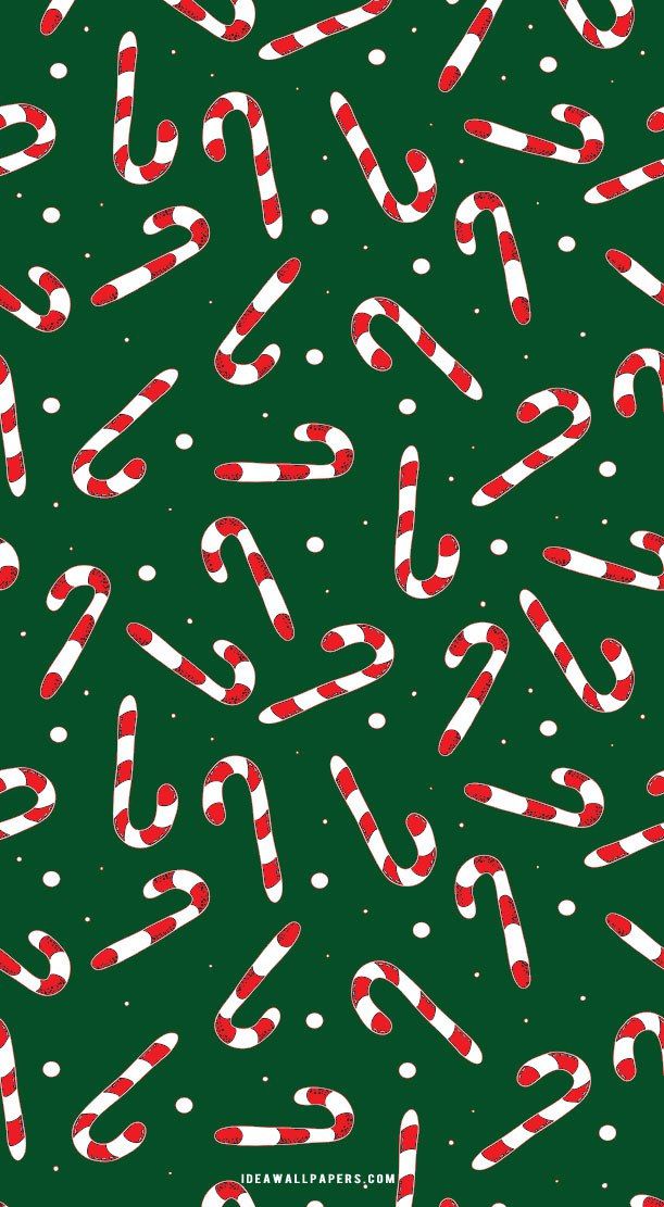 candy canes and snowflakes on a green background for christmas wrapping paper or wallpaper