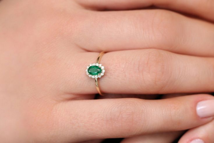 "Emerald Ring / 14k Classic Oval Cut Emerald Ring with Surrounding Diamonds / Natural Emerald Ring in 14k Solid Gold / Mothers Day Gift * If you would like to see the Matching Earrings Please Click Below https://www.etsy.com/listing/604292239/emerald-earrings-14k-oval-cut-emerald?ref=related-4 * If you would like to see the Matching Necklace Please click Below https://www.etsy.com/listing/590436480/emerald-necklace-14k-classic-oval-cut?ref=related-1 Item Features * Made to Order. * Gold KT: 14K 14k Yellow Gold Cluster Ring With Oval Shape, Elegant Cluster Birthstone Rings, Elegant Birthstone Cluster Rings, Dainty Oval Diamond Ring For Anniversary, Dainty Oval Ring With Halo Setting, Dainty Oval Halo Setting Rings, Dainty Oval Diamond Anniversary Ring, Dainty Oval Rings With Halo Setting, Dainty Oval Halo Rings