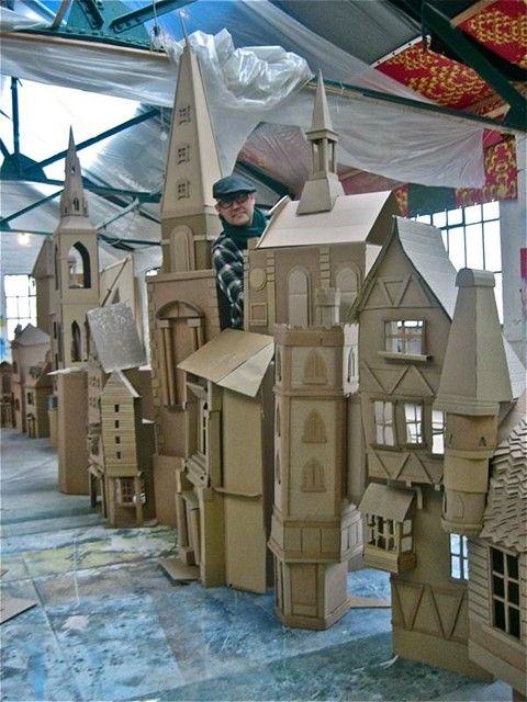 a man standing in front of a cardboard castle