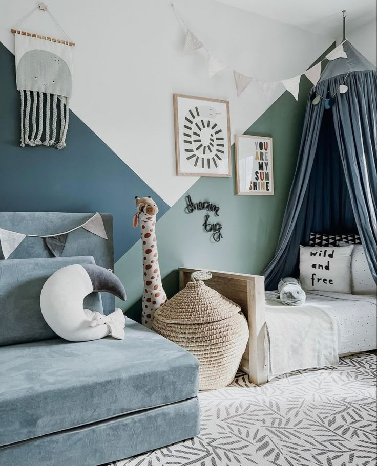 a child's bedroom decorated in shades of blue, white and grey with a giraffe stuffed animal