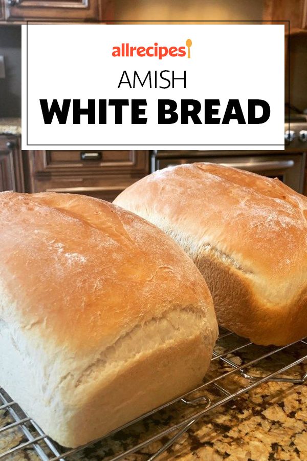 two loaves of white bread sitting on top of a cooling rack in a kitchen