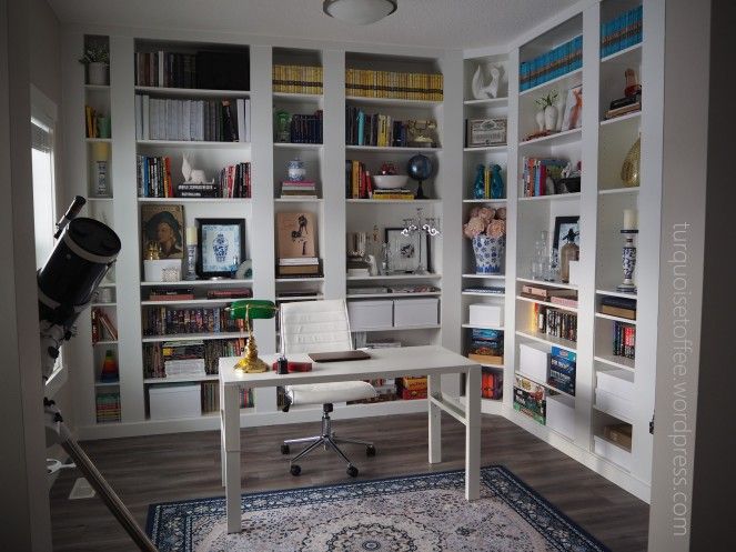 a room with bookshelves and a rug on the floor in front of it