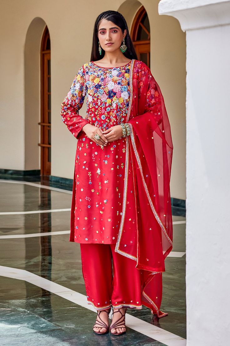 Red silk kurta crafted in rich silk and highlighted with vibrant, garden-inspired embroidery featuring a medley of sequins, beads, resham, stones, zari work, salli, and flower tikki motifs. Paired with a silk pant and organza dupatta.
Components: 3
Pattern: Embroidered
Type Of Work: Sequin, Bead, Resham, Stone
Neckline: Boat
Sleeve Type: Long
Fabric: Kurta and Pant: Silk, Dupatta: Organza
Color: Red
Other Details: 
Model is wearing size M
Occasion: Mehendi and Haldi - Aza Fashions Elegant Multicolor Silk Sharara, Red Designer Unstitched Georgette Suit, Festival Red Georgette Unstitched Suit, Red Georgette Unstitched Suit For Festivals, Red Unstitched Suit With Sheer Dupatta For Festivals, Red Silk Unstitched Suit For Eid, Red Silk Straight Kurta, Eid Red Silk Unstitched Suit, Red Silk Unstitched Suit With Resham Embroidery