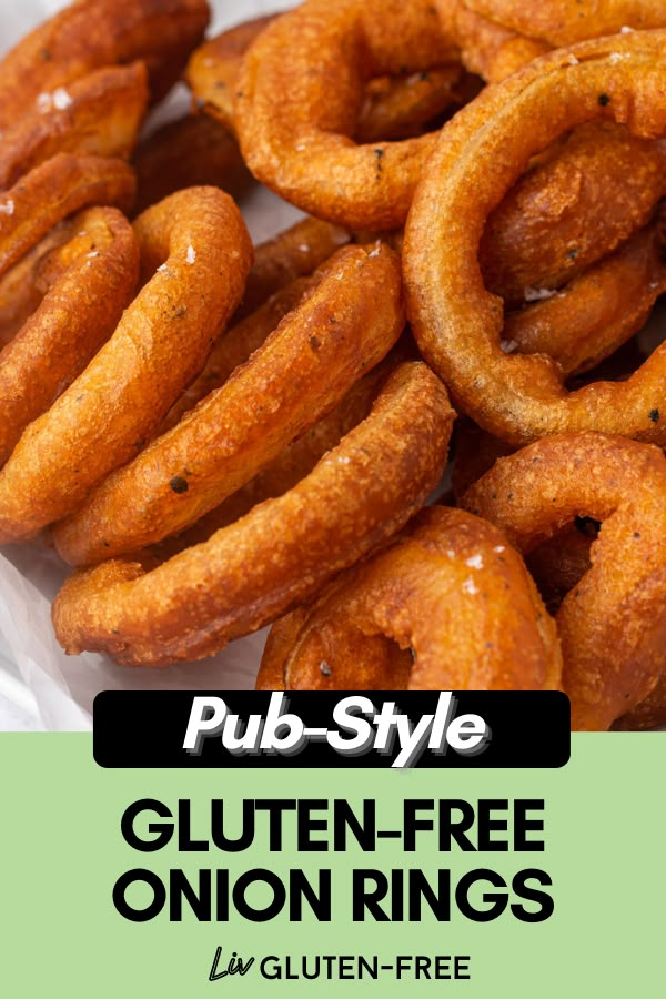 a pile of fried onion rings sitting on top of a white paper bag with the title pub - style gluten - free onion rings