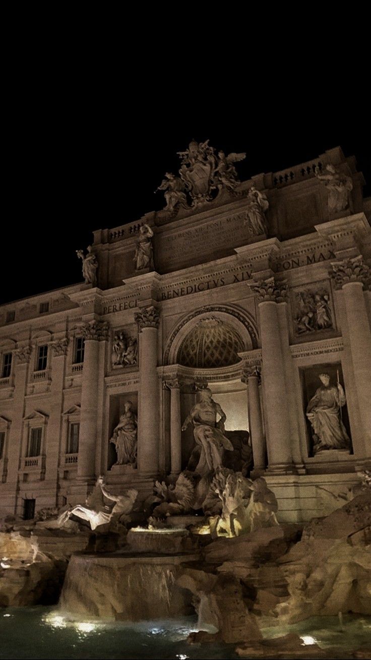 the building has many statues on it at night