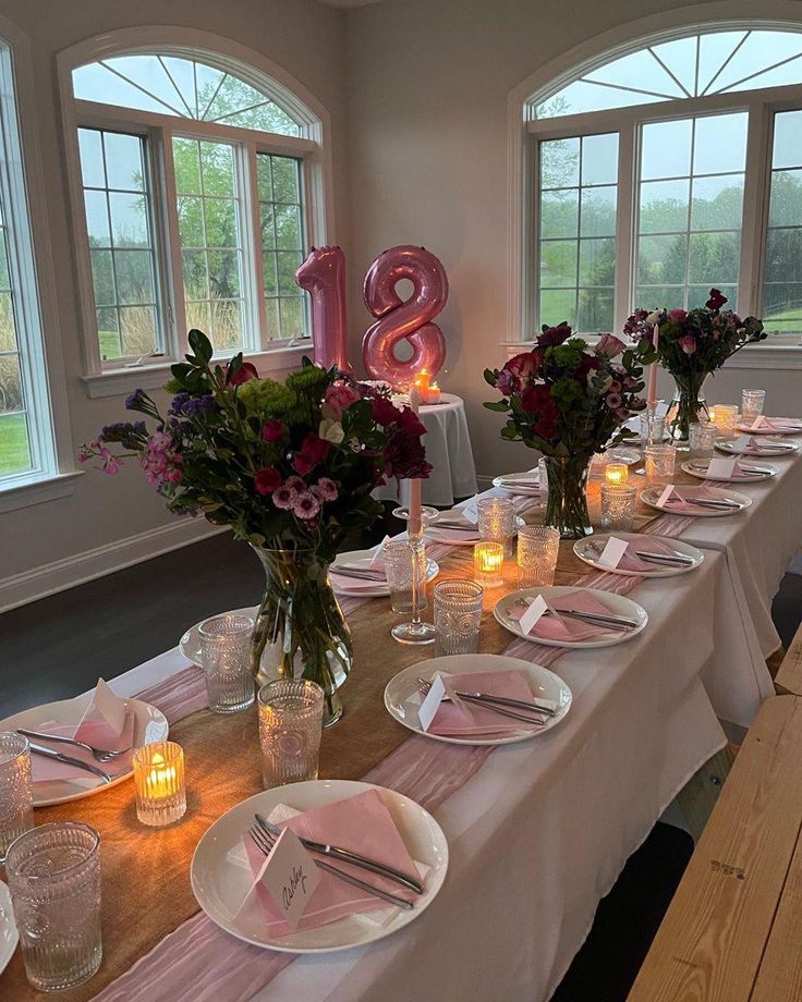 the table is set with pink napkins and candles for an elegant dinner or celebration