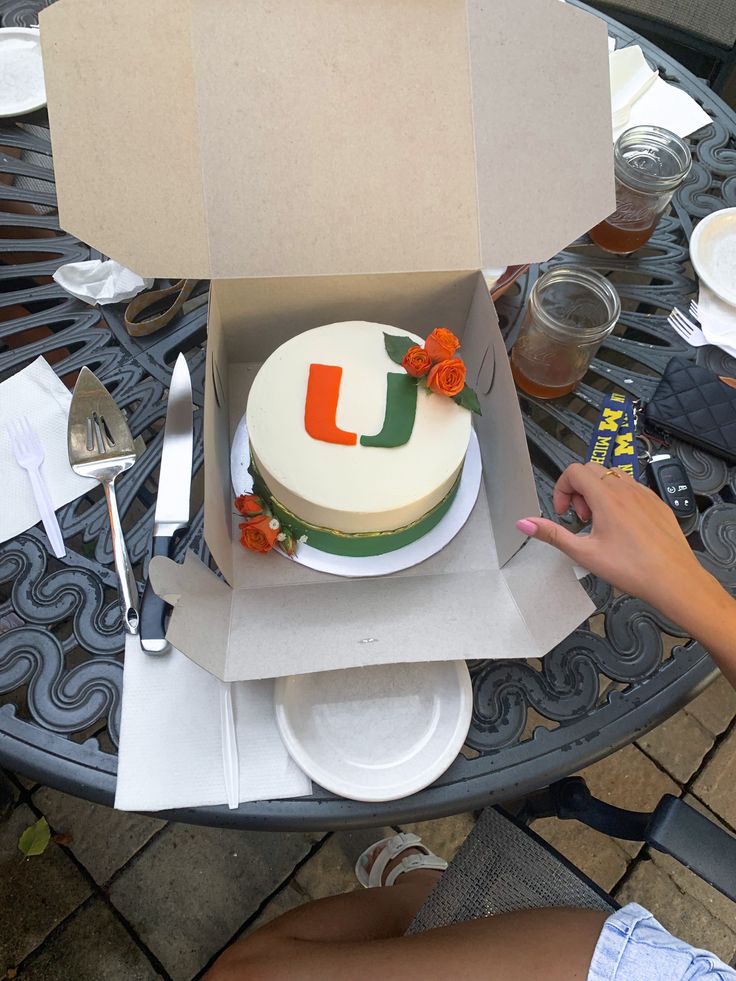 a cake in a box with the letter u on it sitting on top of a table