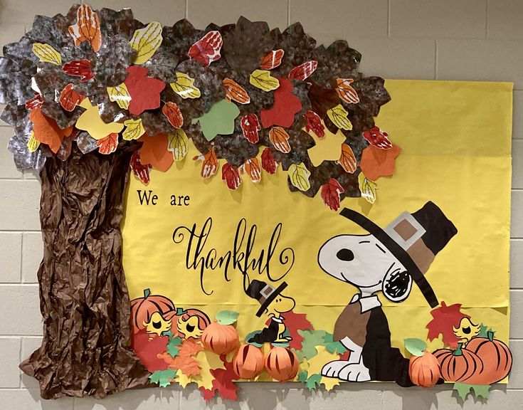 a bulletin board is decorated with fall leaves and a charlie the peanuts character on it