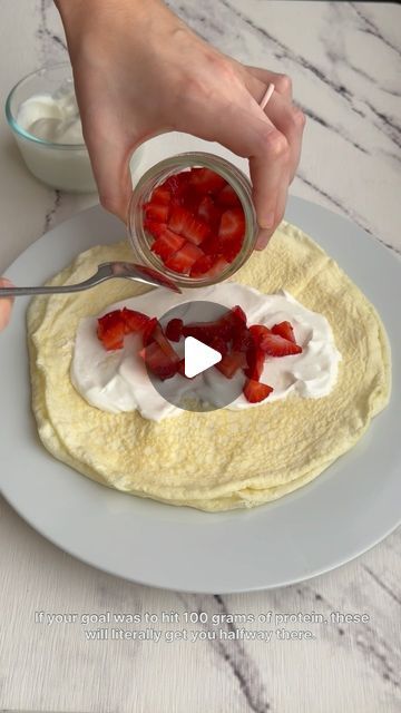 someone is adding strawberries to the top of a tortilla on a plate