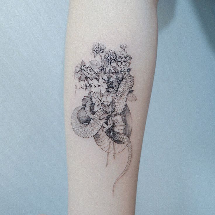 a woman's arm with flowers and leaves on the left side of her body