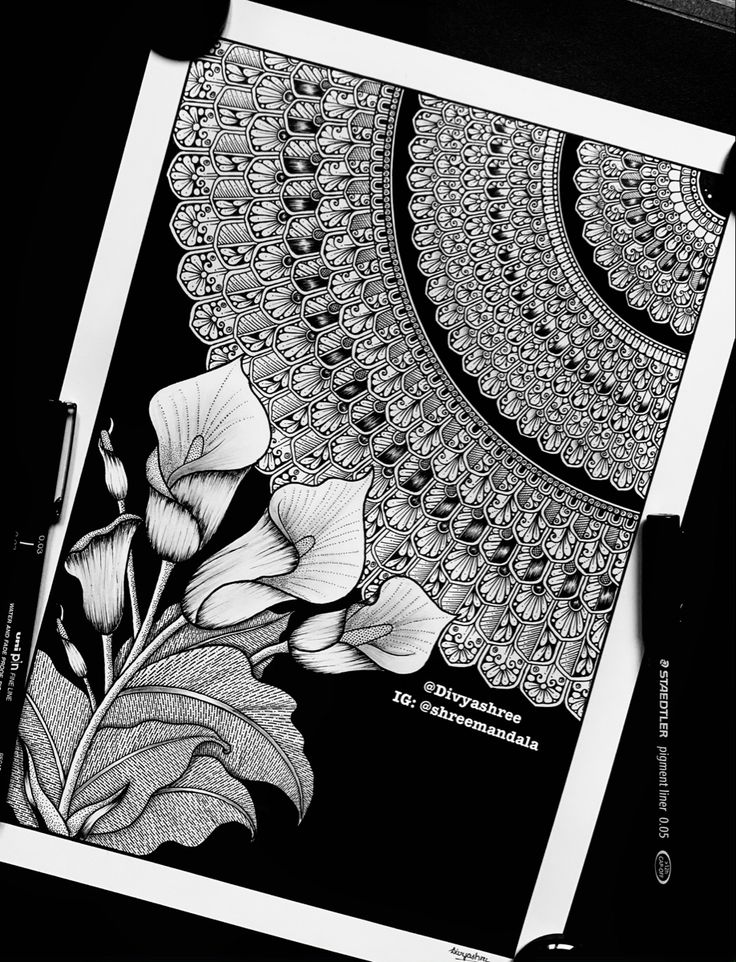 a black and white photo of flowers on a paper with an intricate lace border in the background