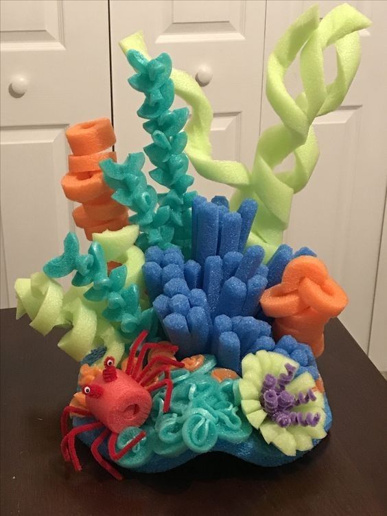 a vase filled with colorful sea life on top of a table