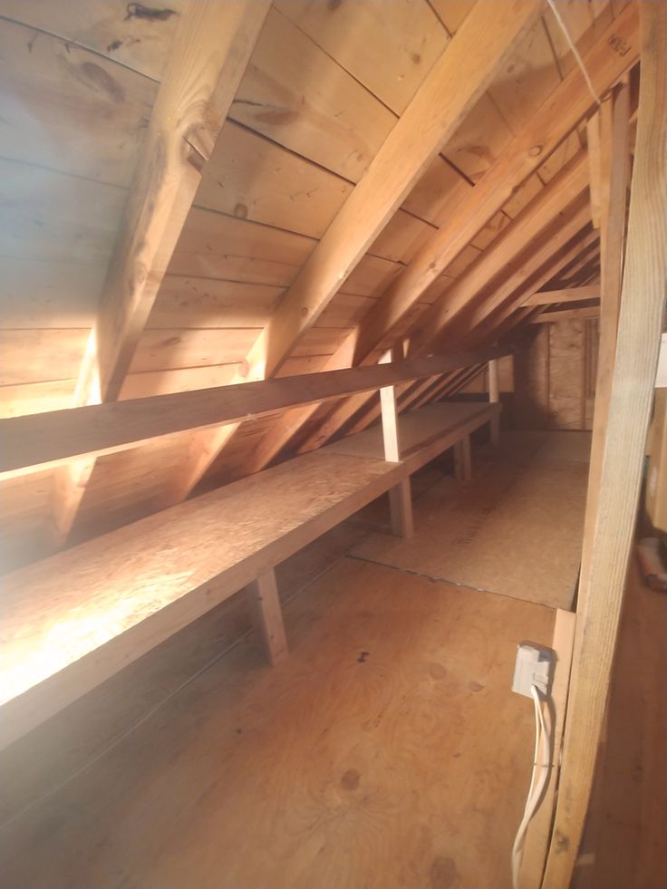 an attic with wooden beams and benches in it