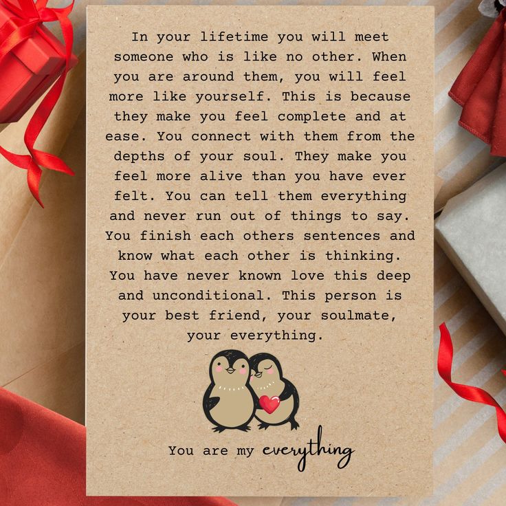 a card with two penguins on it next to some wrapped presents and a red ribbon