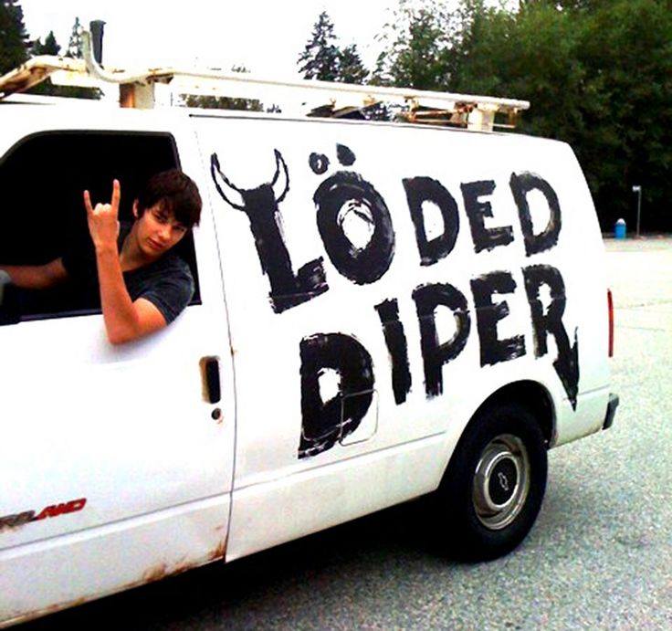 a young man sitting in the driver's seat of a white truck that says loaded diper