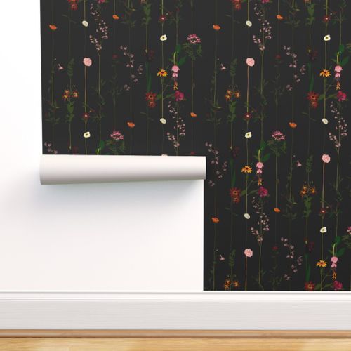 a wall with flowers on it next to a black wallpaper and a wooden floor