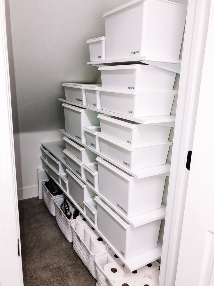 a closet filled with lots of white bins