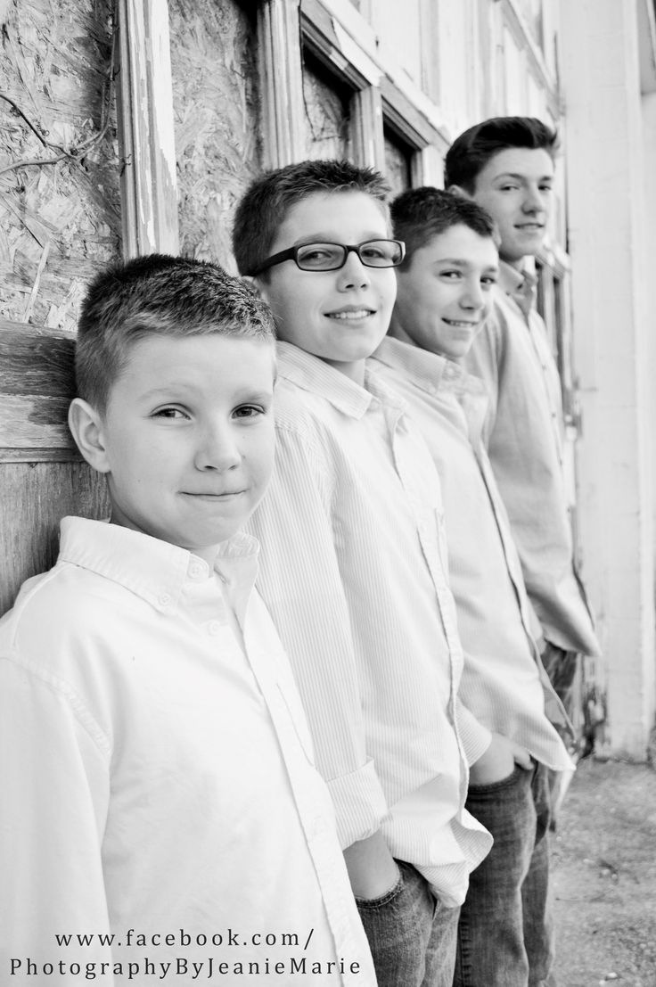 black and white photograph of three boys leaning against a wall