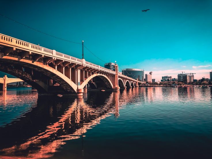 a bridge over water with buildings in the background