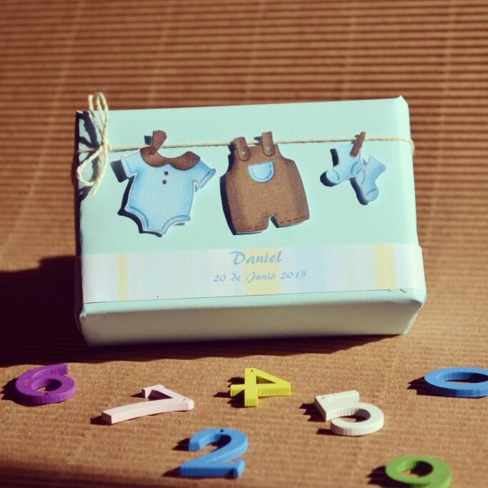 a baby's first birthday gift box with clothes hanging from it and numbers on the ground