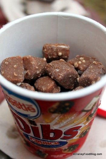 a paper cup filled with brownies sitting on top of a table