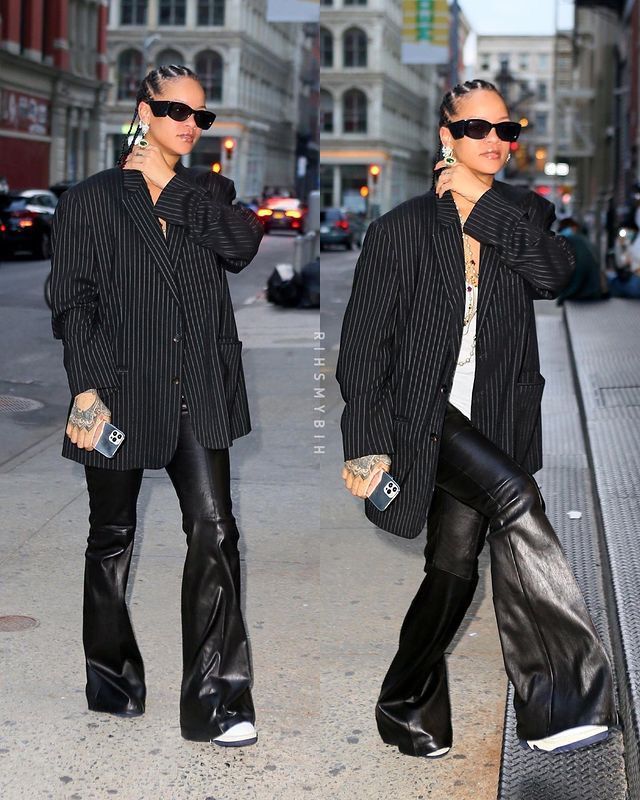 two women walking down the street wearing black leather pants