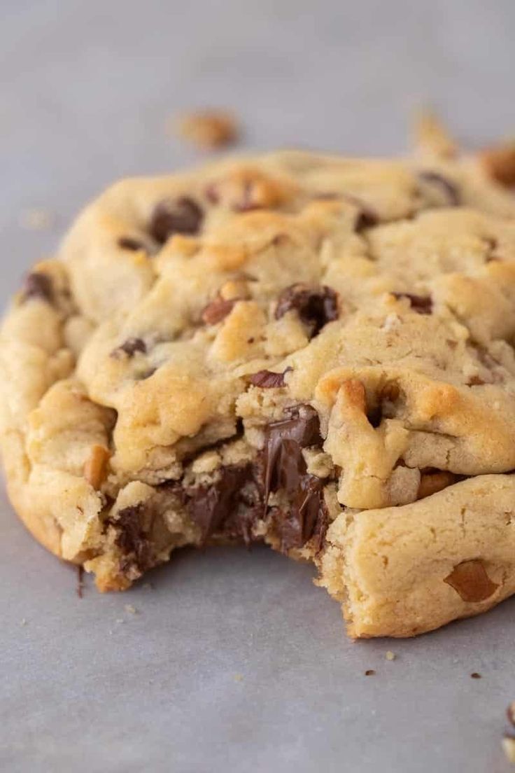 a chocolate chip cookie is cut in half and sitting on a counter top with one bite taken out